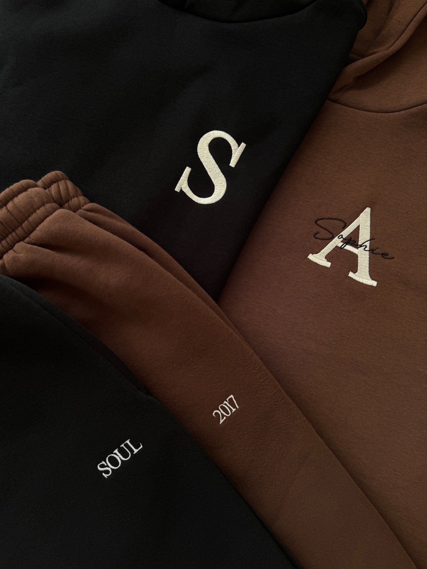 Detailansicht der hochwertigen Stickerei: Name und Initiale auf einem flauschigen Jogginganzug, DaUnique Handarbeit